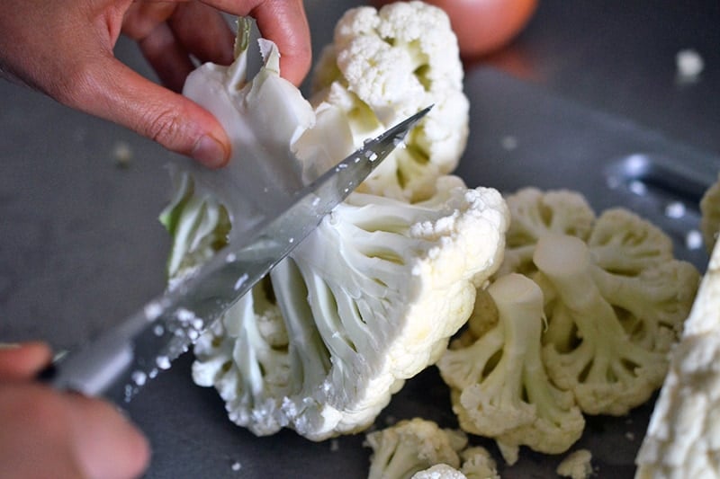 Cutting up a cauliflower into uniform florets to make cauliflower mashed potatoes.