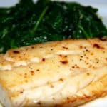 Paleo and Whole30 easy sous vide wild alaskan cod on a plate with steamed spinach.