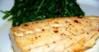 Paleo and Whole30 easy sous vide wild alaskan cod on a plate with steamed spinach.