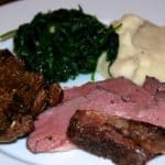 A plate of sous vide mustard and herb seasoned butterflied lamb leg with garlic cauliflower mash and spinach.