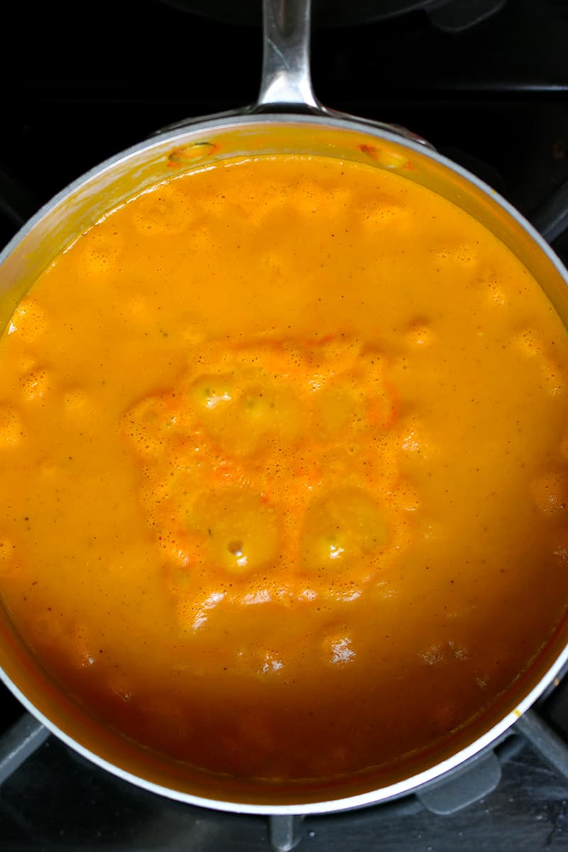 An overhead shot of simmering cream of tomato soup