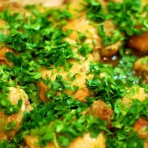 Whole30 roast chicken in a baking dish topped with chopped parsley.