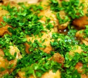 Whole30 roast chicken in a baking dish topped with chopped parsley.