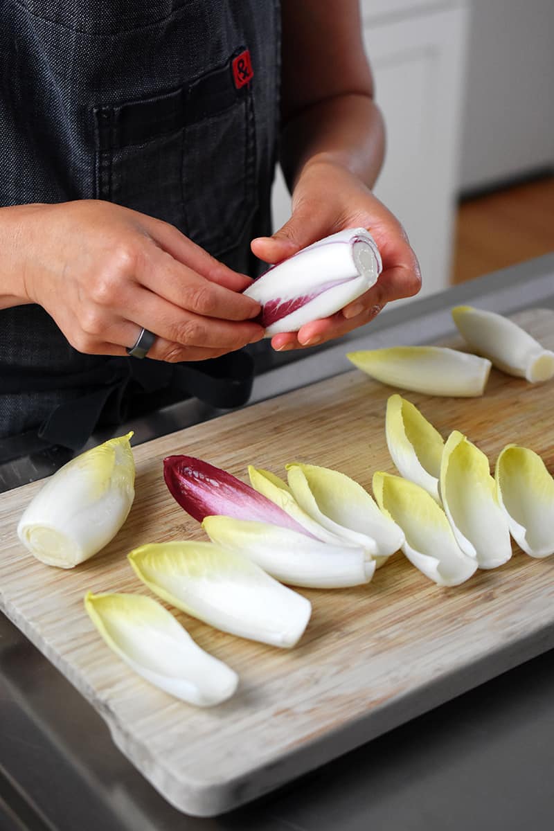 Someone separating Belgian endive into spears.