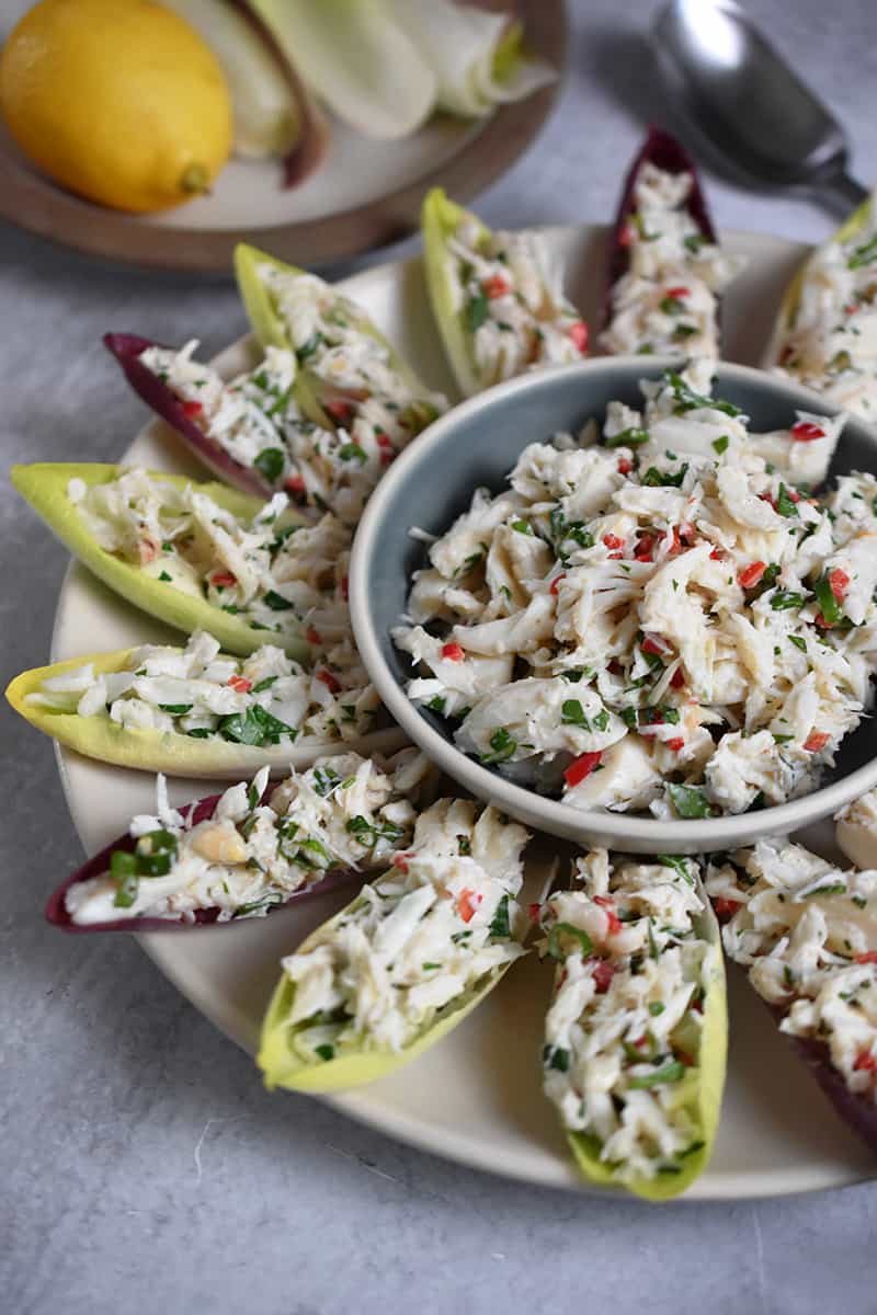 A side view of a platter filled with endive spears with crab salad.