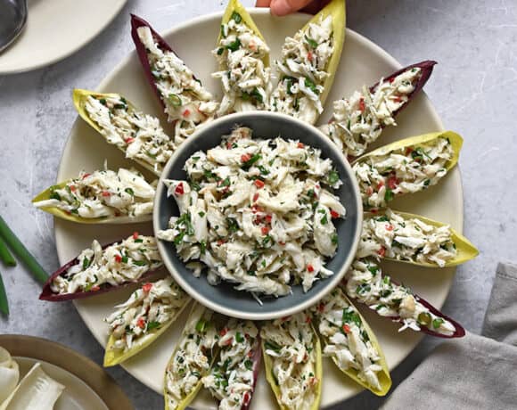 An overhead shot of a platter of endive spears filled with simple crab salad