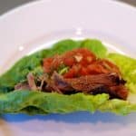 Overnight oven-braised shredded pork in a paleo and whole30 lettuce taco.
