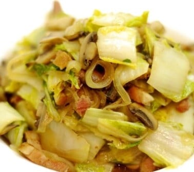 A bowl of the Whole30 and paleo recipe of stir fried napa cabbage with mushrooms and bacon.