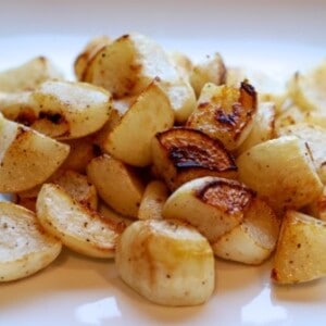 A plate of roasted turnips cut into cubes.