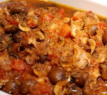 A microwave safe dish is filled with slow cooker chicken cacciatore.