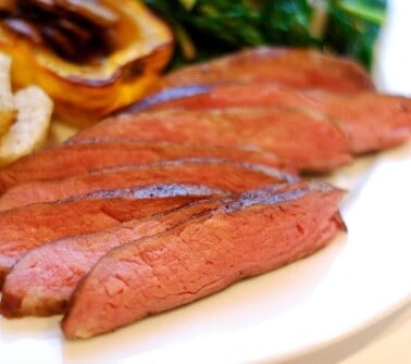 A plate of flank steak cooked sous vide cut up into thin strips.