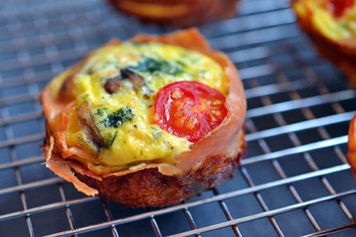 An overhead shot of a Prosciutto-Wrapped Frittata Muffin on a cooling rack