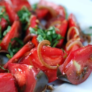 A platter of Tomato and Basil salad on a white plate.