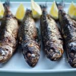 Broiled sardines on a plate.
