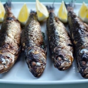 Broiled sardines on a plate.