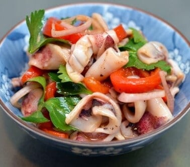 Bowl of grilled calamari with roasted peppers.
