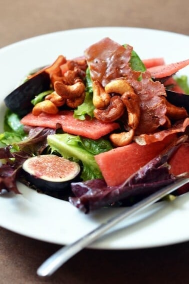 Plate of fig and watermelon salad with honey vanilla cashews