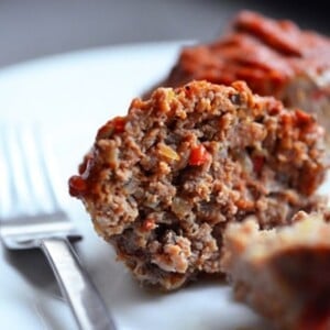 A plate with a paleo meatloaf muffin cut in half.