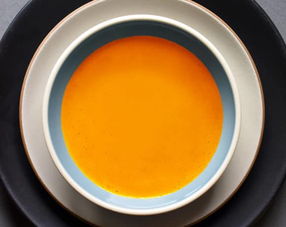 An overhead shot of Carrot Cardamom soup in a serving bowl.