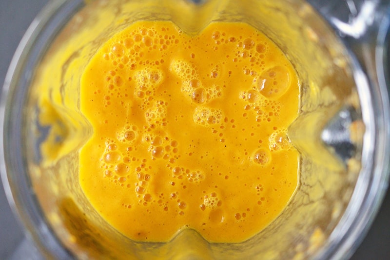 An overhead shot of pureed Carrot Cardamom Soup in a Vitamix blender