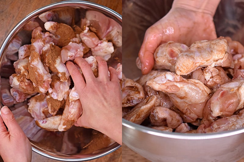 Someone tossing by hand chicken wings with marinade in a bowl.