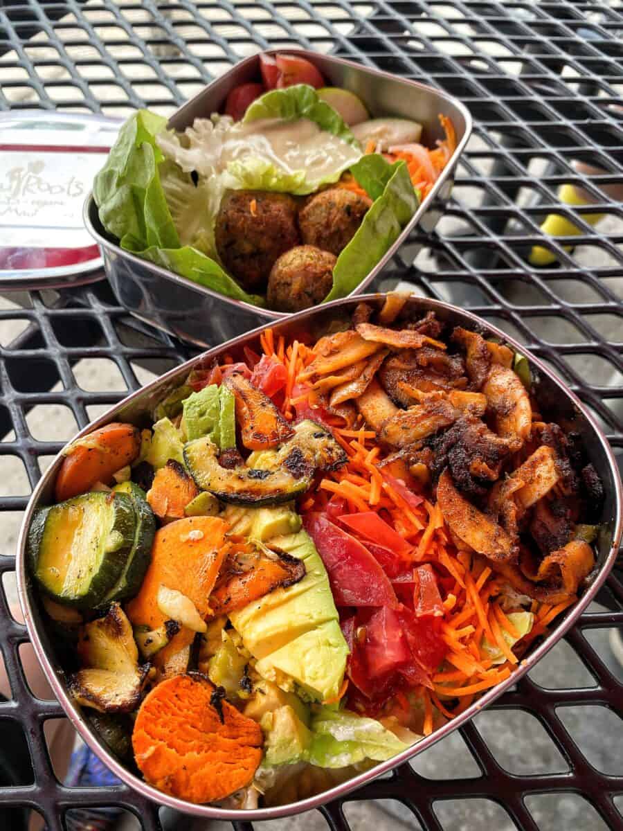 Two stainless steel containers filled with gluten-free vegan salads from Moku Roots in Maui