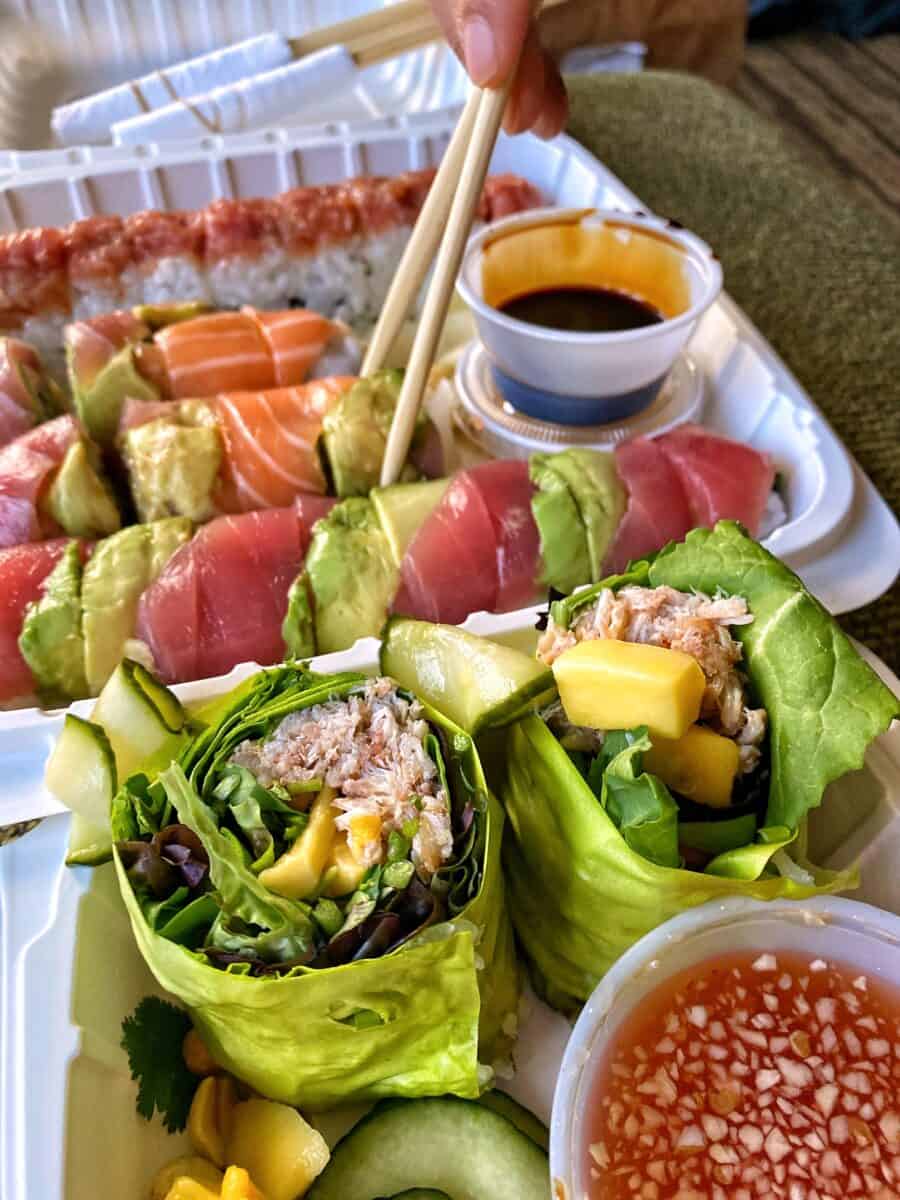 An overhead shot of takeout containers filled with gluten-free sushi from Sansei in Maui