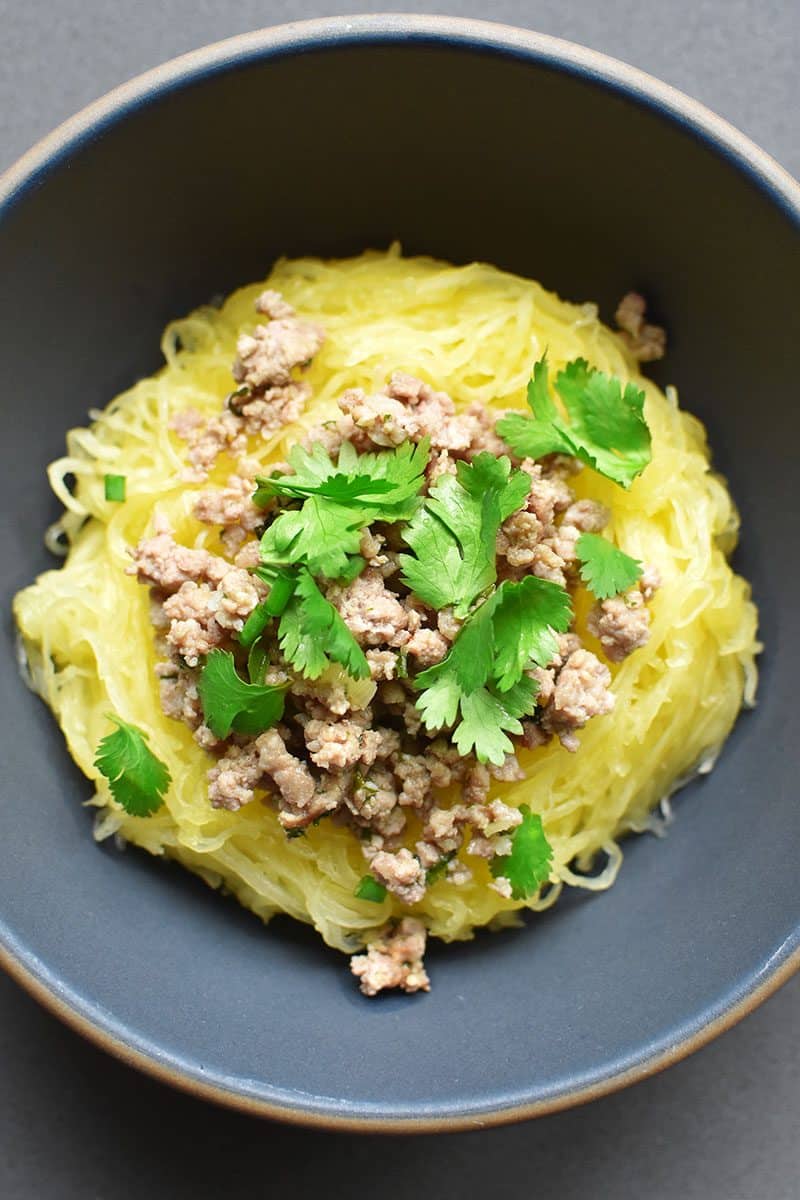 An overhead shot of a bowl of Instant Pot spaghetti squash topped with stir-fried ground pork and cilantro.
