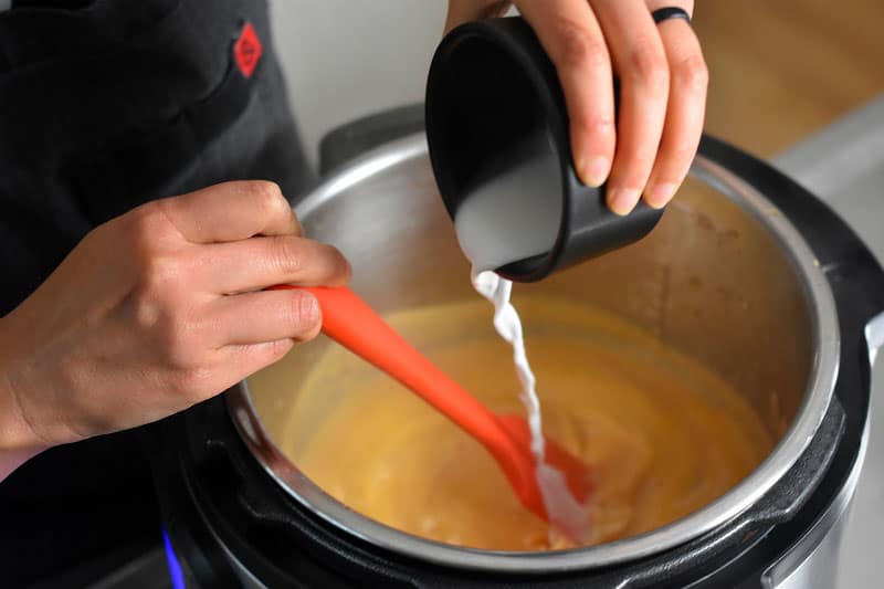 Arrowroot slurry is poured into an Instant Pot to thicken the gravy.