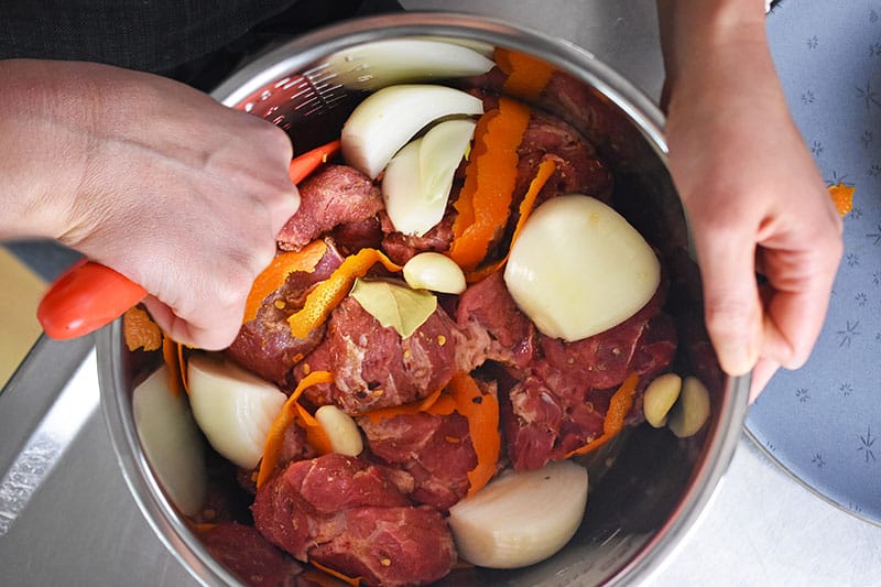 An overhead shot of someone mixing the carnitas ingredients in the Instant Pot