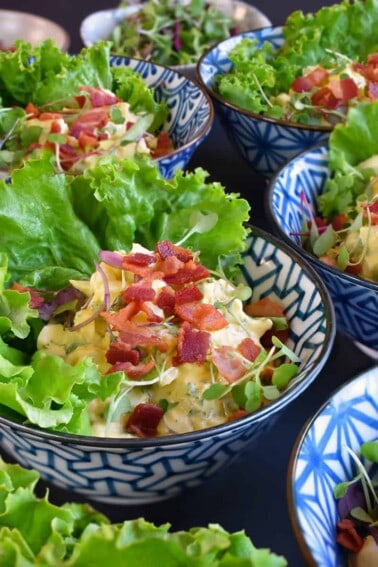An overhead shot of Bacon Deviled Egg Salad in blue and white bowls.