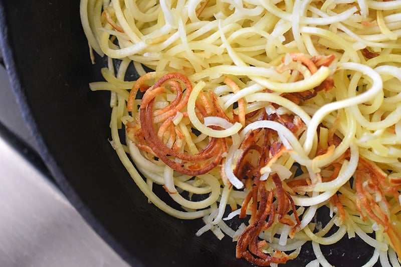 A closeup shot of crispy sweet potato noodles in a pan.