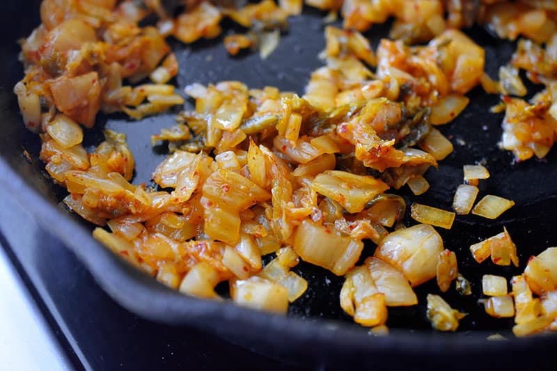 Fried onions and kimchi in a pan.