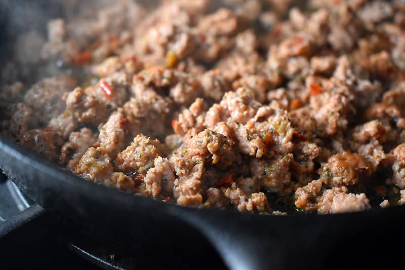A closeup of the cooked Italian sausage in the cast iron skillet.