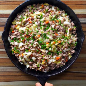 An overhead shot of a frying pan filled with Egg Roll In A Bowl (also known as Potsticker Stir-Fry), a keto, paleo, and Whole30 one-pan meal.
