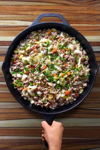 An overhead shot of a frying pan filled with Egg Roll In A Bowl (also known as Potsticker Stir-Fry), a keto, paleo, and Whole30 one-pan meal.
