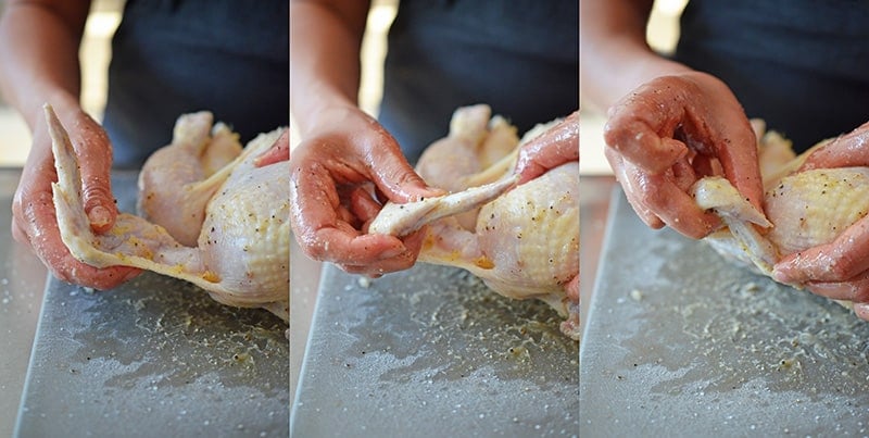 Tucking the wings behind the back of a raw whole chicken to make Whole30 weeknight roast chicken