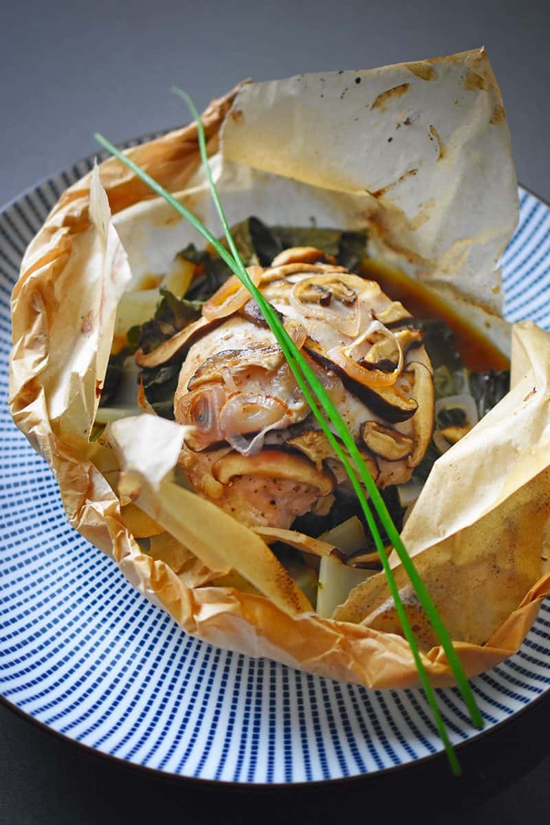 A packet of the paleo paper-wrapped chicken opened up to display the ingredients inside.