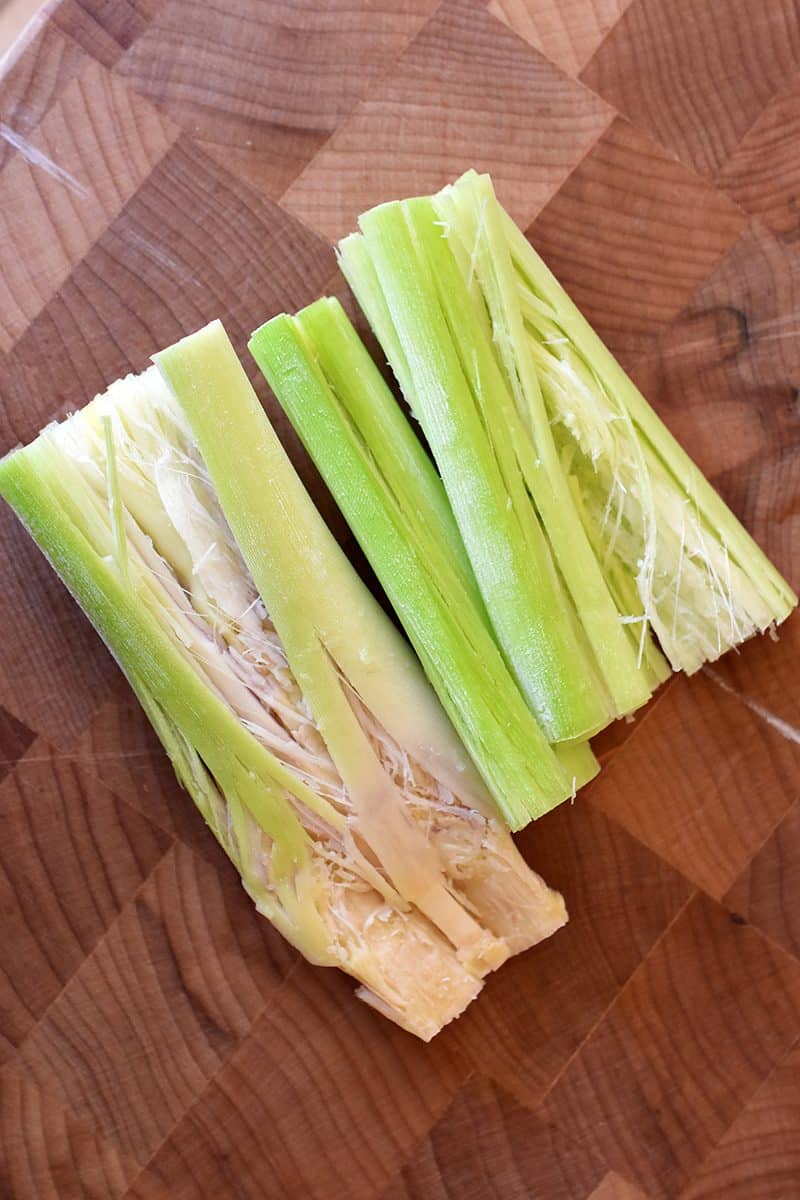 Trimmed lemongrass that has been pounded with a mallet. This lemongrass is ready for soups and stews.