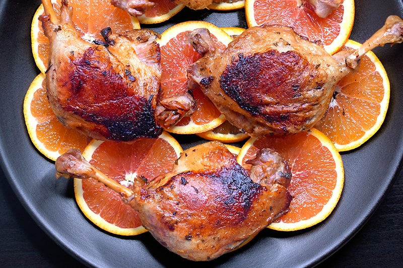 An overhead shot of a platter topped with Instant Pot (Pressure Cooker) Orange Duck legs