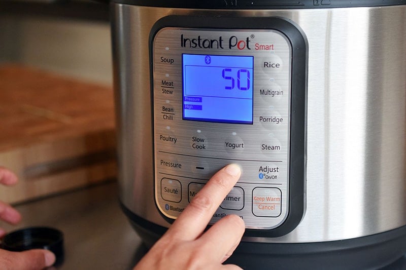Programming an Instant Pot to cook under high pressure for 50 minutes.