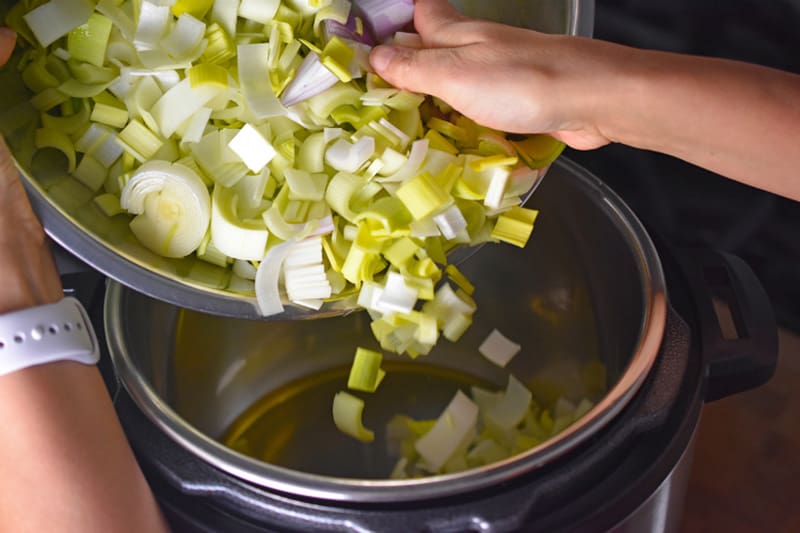 Adding leeks to an Instant Pot to make Whole30 Curried Cream of Broccoli Soup 