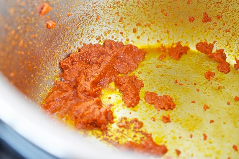 Curry paste is added to the hot Instant Pot insert.