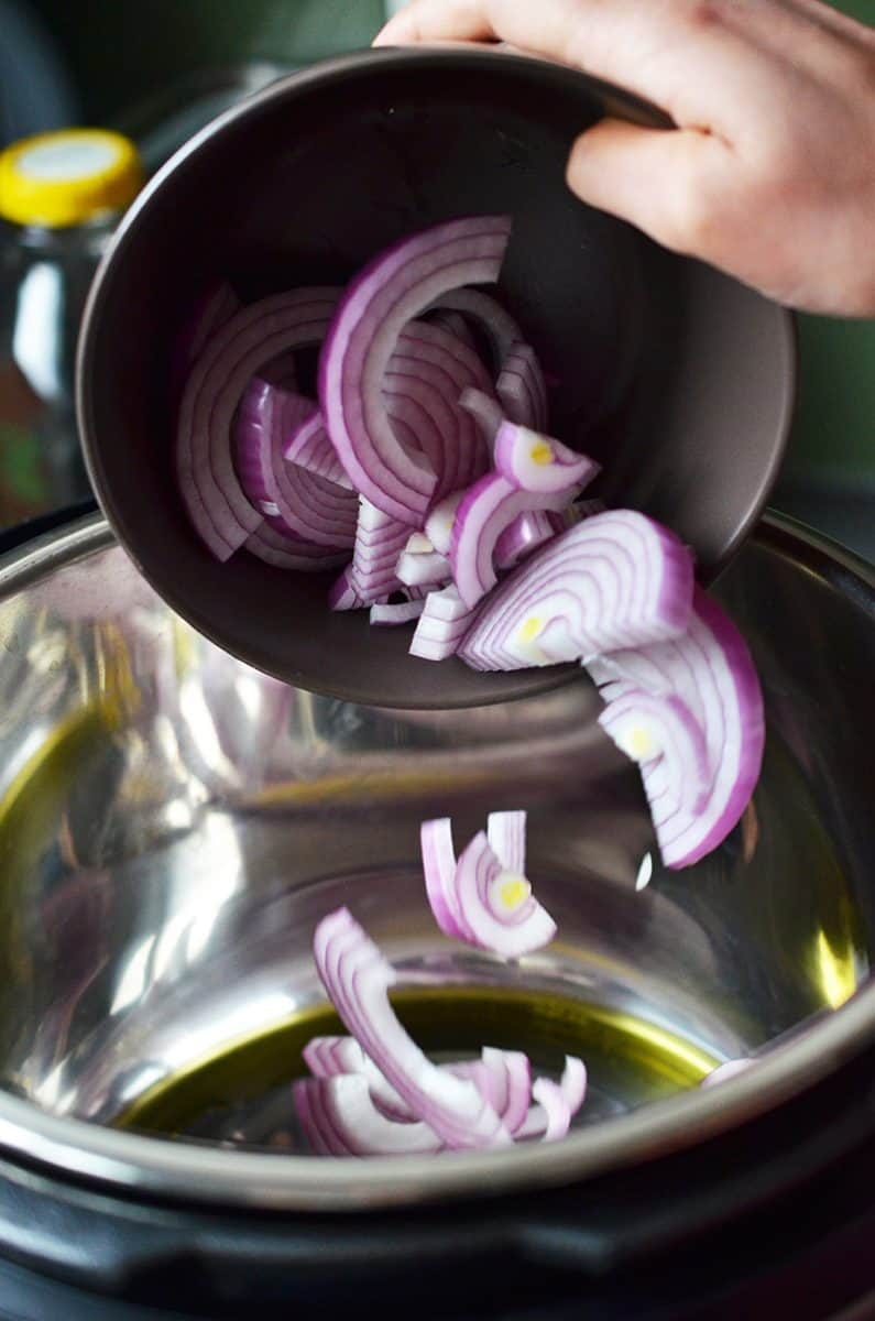 Sliced red onions are added to an Instant Pot