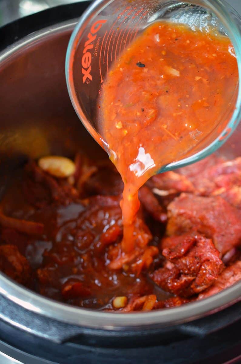 Salsa is poured over the beef in the Instant Pot