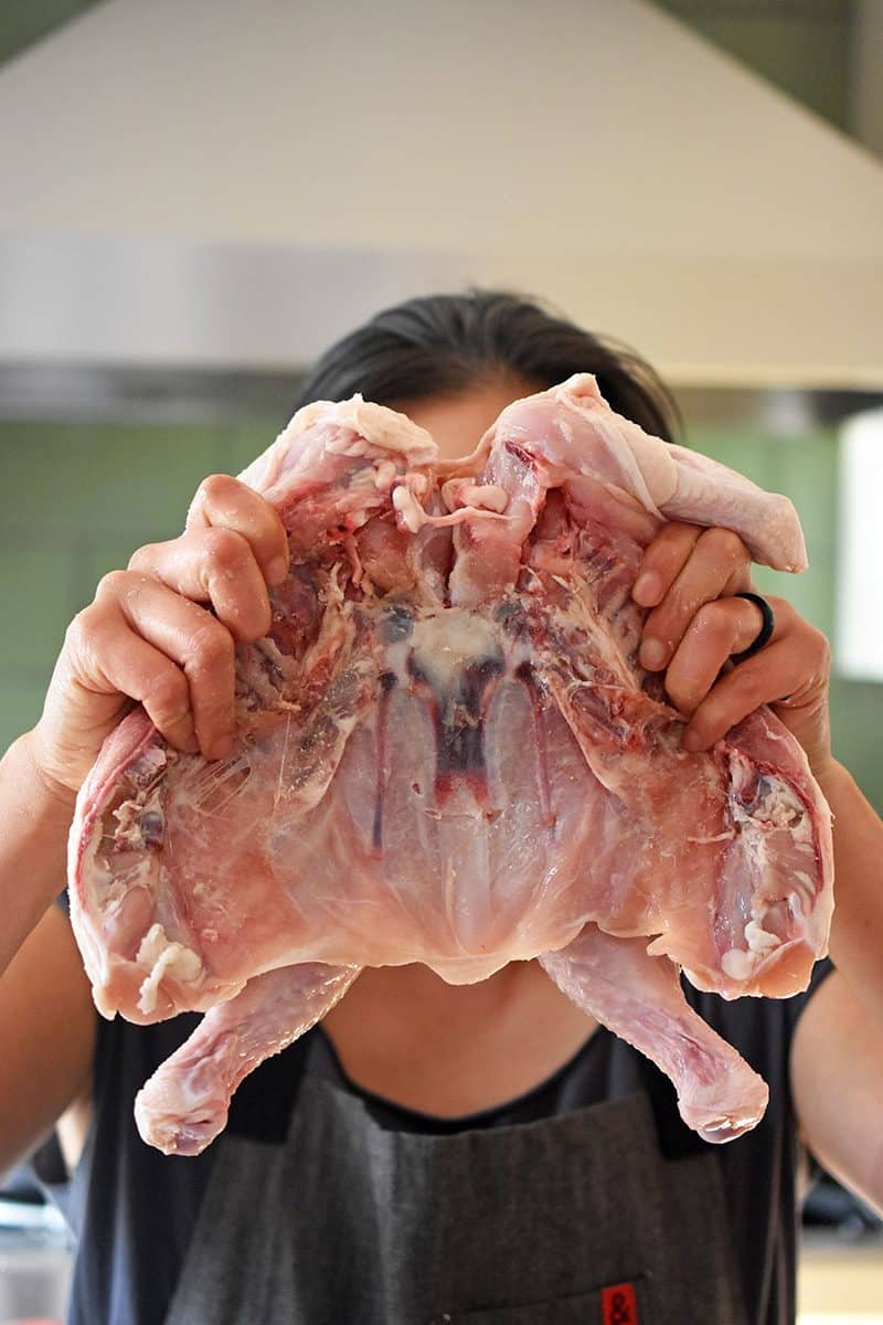 Holding a flattened chicken in front of a person's face