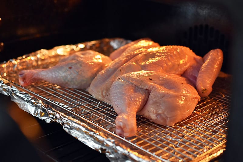 Placing the Spatchcocked Chicken with Herb Butter into the oven