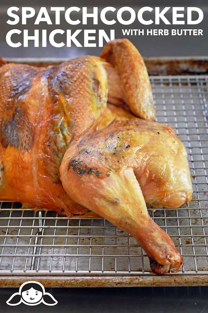 A Spatchcocked Chicken with Herb Butter on a wired rack in a rimmed baking sheet