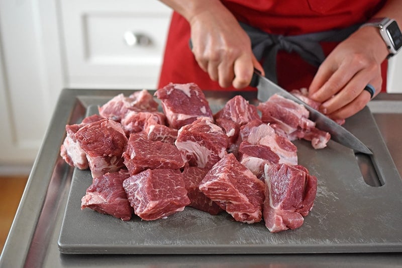 Cutting pork shoulder roast into cubes for Instant Pot Spicy Pineapple Pork Stew