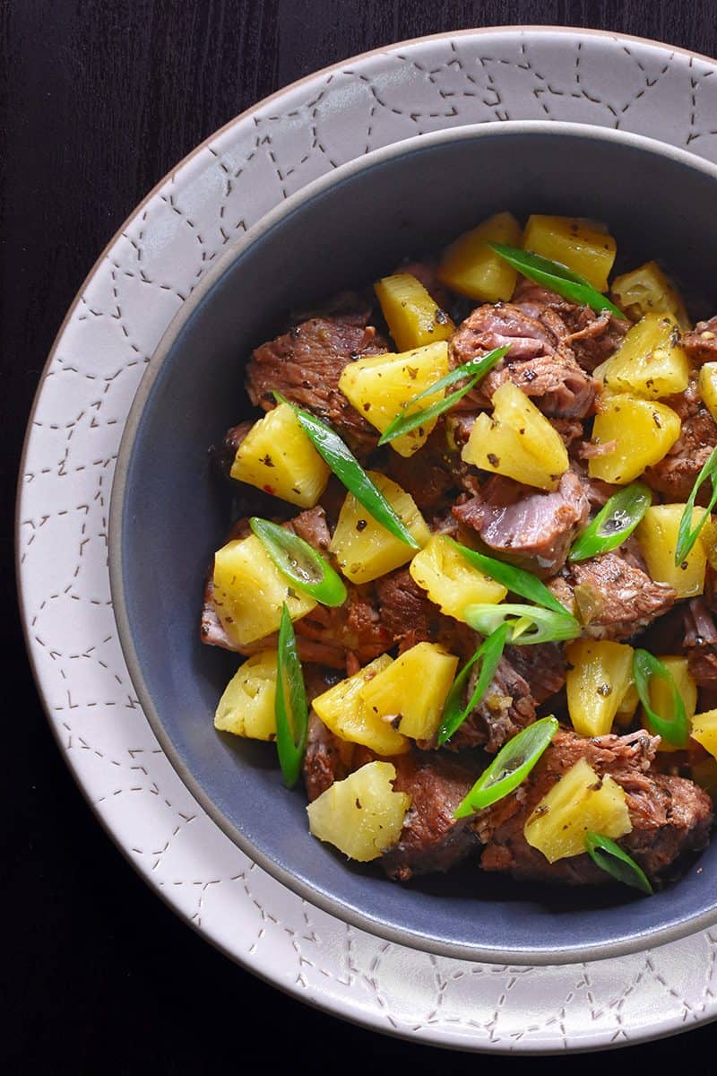An overhead shot of Instant Pot Spicy Pineapple Pork topped with sliced scallions